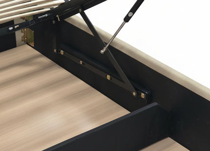 Close-up of a bed frame with a lift-up headboard mechanism, showing black metal supports, light wood slats, and a gray upholstered headboard in a bedroom setting.