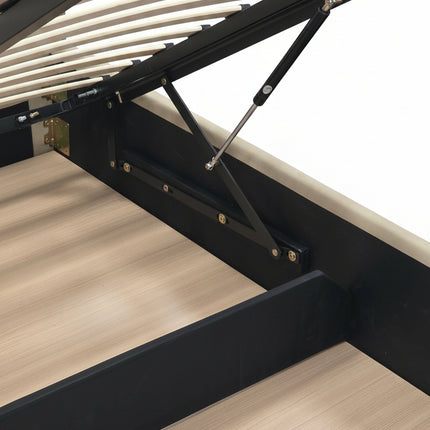 Close-up of a bed frame with a lift-up headboard mechanism, showing black metal supports, light wood slats, and a gray upholstered headboard in a bedroom setting.