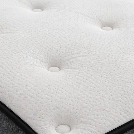 Close-up of a white tufted mattress or cushion surface with buttoned depressions and a black edge visible along the bottom.