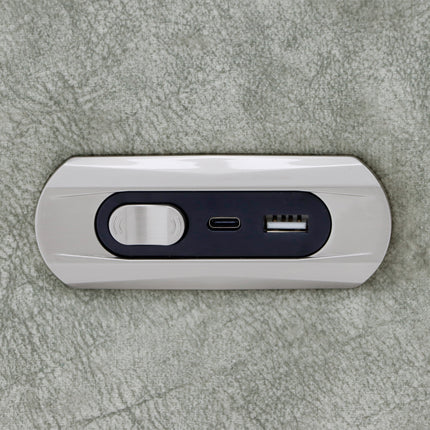 A slim, rectangular portable power bank with a glossy white outer shell and a dark navy blue center panel featuring a circular magnetic charging area, a USB-C port, and a USB-A port, shown on a textured grey surface.