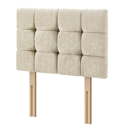 A tufted upholstered headboard in a light beige fabric, supported by two light wood legs, shown against a plain white background.