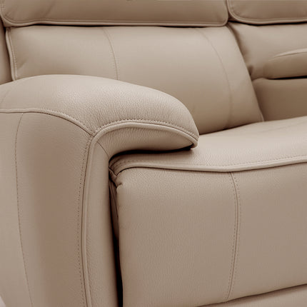 Close-up of a beige leather reclining sofa showing the armrest, seat cushion, and stitching detail.