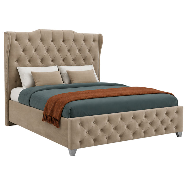 A tufted wingback bed ottoman divan bed upholstered in beige fabric, styled with a dark teal duvet, two beige pillows, and a rust-orange throw blanket, shown on a solid white background.