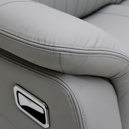 Close-up of a light grey leather recliner chair showing the armrest, stitching, and a chrome control panel.